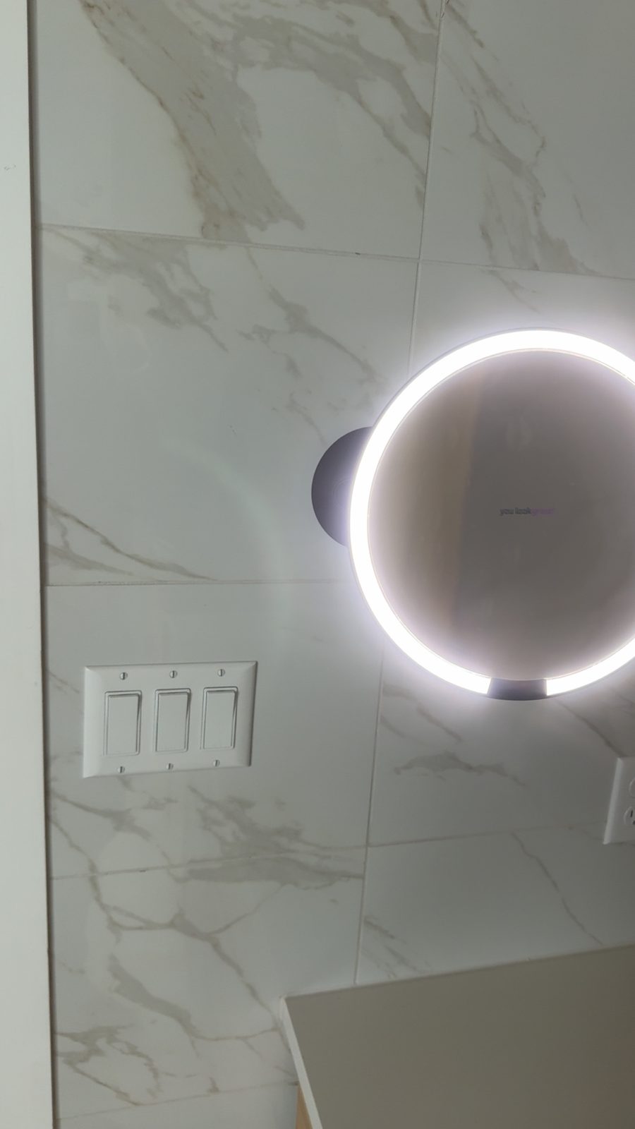 Hardwired LED mirror with matching rocker controls.