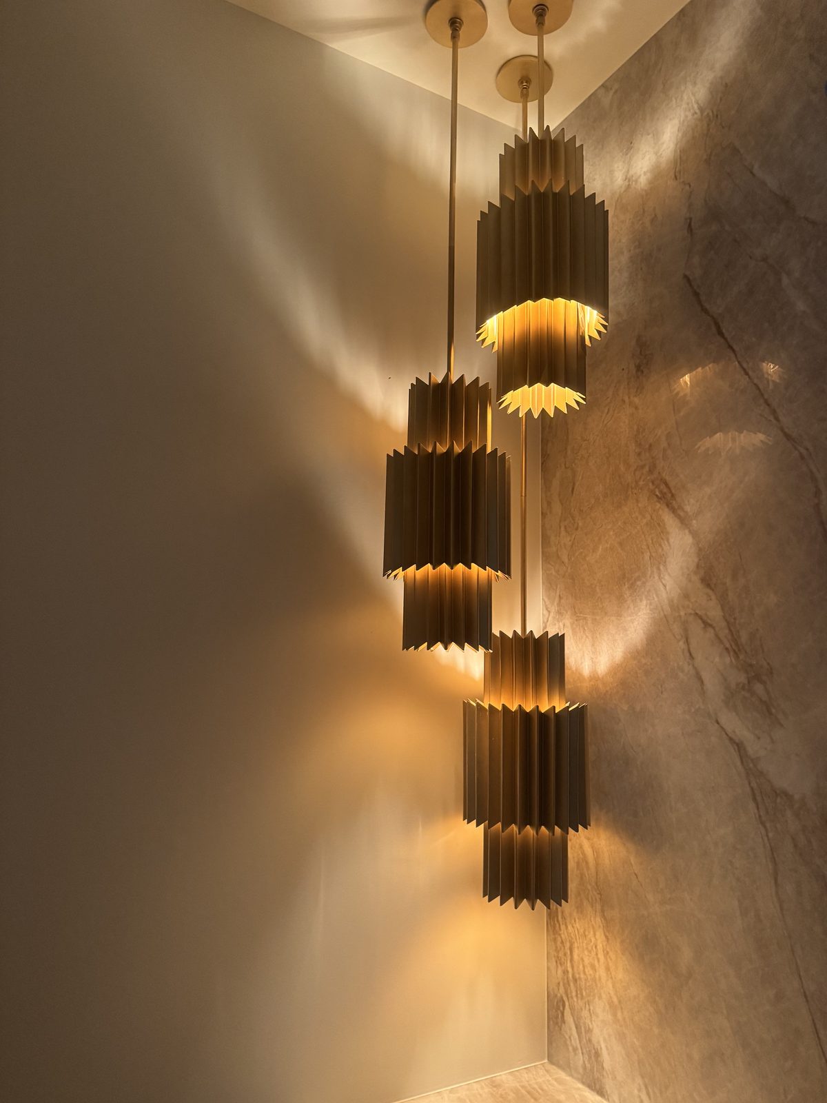 Multi-tier brass fixture stepped down an open stairwell.